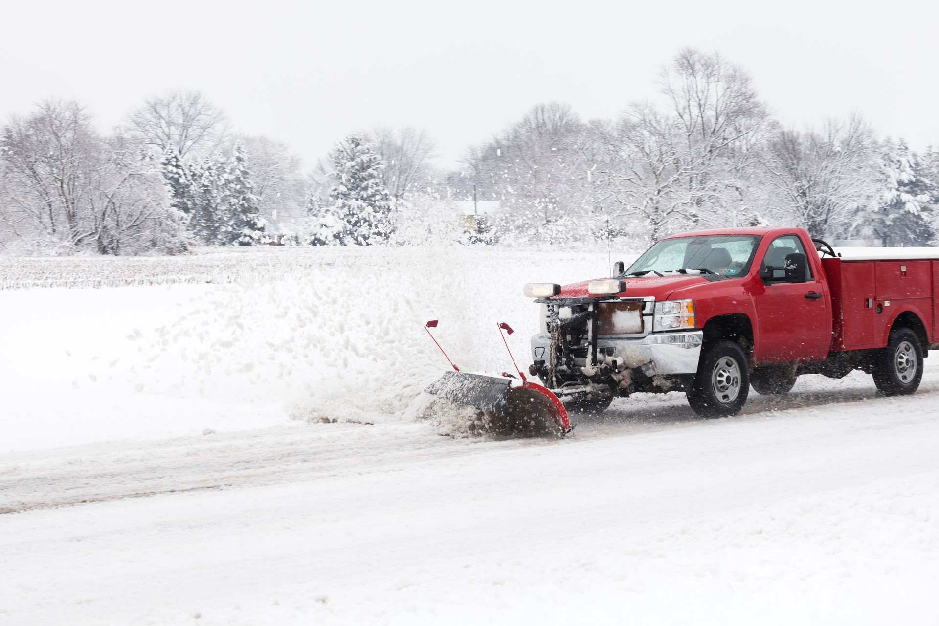 Smaller Truck with Snow Plow Plowing and Country Road